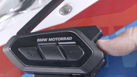 Um polegar está a clicar na tecla Mesh do ConnectedRide Com U1.